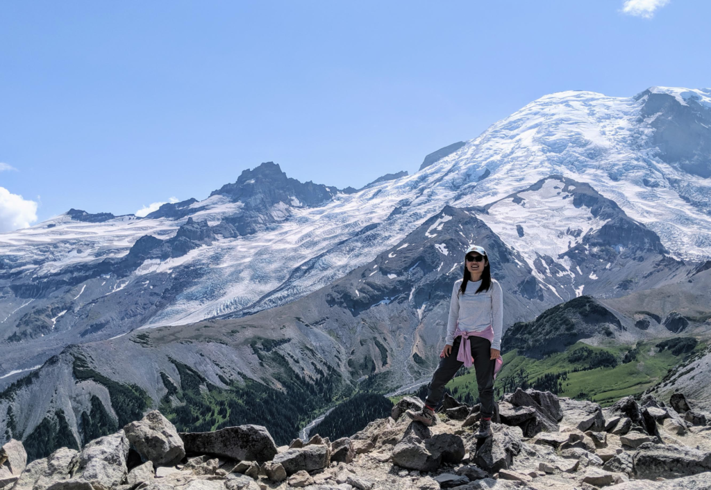 MCIT Online student, Xunjing Wu, posing in front of a snow-topped Mt. Rainier.